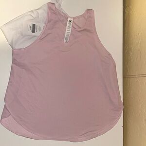 Two Fabletics Cashel cropped swing tanks